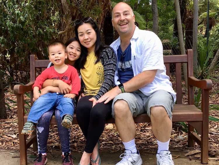 Family of 4 sitting on a park bench