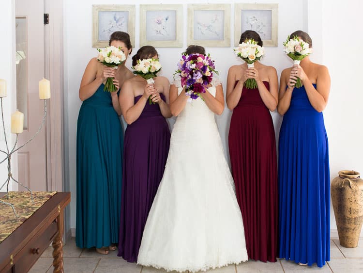 Bridal Party holding flowers in front of thier faces