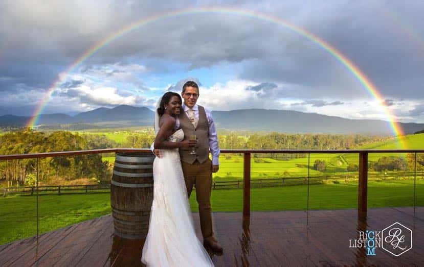 Newlyweds under a full rainbow over the Yarra Valley
