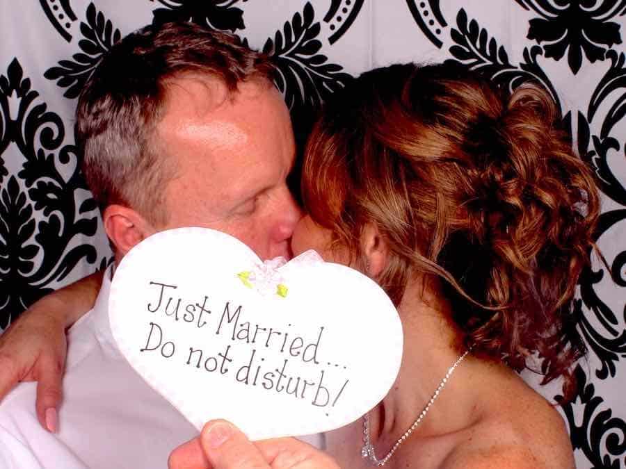 Newlyweds kissing in a classic photo booth