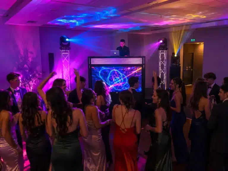 Armada Video DJ Booth entertaining guests at a school formal and valedictory celebration with students dancing in front of an elevated stage.